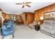 Open-concept living and dining area featuring wood paneling, comfortable seating, and a vintage dining set at 9751 N Highway 96, Selma, NC 27576