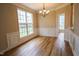 Formal dining room with modern chandelier, wood floors, and wainscoting, creating an inviting ambiance at 10 London Way, Spring Lake, NC 28390
