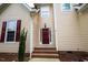 Inviting entrance with a red front door, brick steps, and decorative window, creating a welcoming curb appeal at 10 London Way, Spring Lake, NC 28390