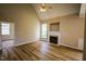 Spacious living room with vaulted ceilings, wood flooring, a fireplace, and natural light, creating a cozy ambiance at 10 London Way, Spring Lake, NC 28390