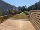Wooden deck with railing overlooks a green lawn and surrounding trees offering privacy at 1000 Regalia Rd # 1, Durham, NC 27713