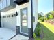 Contemporary townhome exterior showcasing a one-car garage, green door and brick accents at 1000 Regalia Rd # 1, Durham, NC 27713