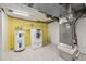 Basement utility area featuring modern appliances, a water heater, and painted walls at 102 W Weatherspoon St, Sanford, NC 27330