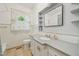 Bathroom with tiled walls and floors, a granite countertop vanity, and framed mirror with shelves at 102 W Weatherspoon St, Sanford, NC 27330