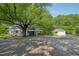 Home featuring screened-in porch, carport, and detached garage surrounded by mature trees at 102 W Weatherspoon St, Sanford, NC 27330
