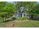 Well-maintained home with lush greenery, a manicured lawn, and a cozy porch, creating a welcoming atmosphere at 102 W Weatherspoon St, Sanford, NC 27330