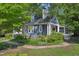 Side view of a blue home with a white-trimmed porch and lush landscaping at 102 W Weatherspoon St, Sanford, NC 27330
