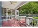 Inviting porch with red painted wood floors and white screen panels overlooking lush greenery at 102 W Weatherspoon St, Sanford, NC 27330