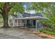 Rear of a home with a screened-in porch and a carport, surrounded by lush trees at 102 W Weatherspoon St, Sanford, NC 27330