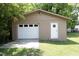 Detached garage with a white roll-up door and a white entry door at 107 Rencher St, Hillsborough, NC 27278