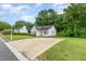 Inviting single-story home with white exterior, dark roof, ample driveway, and beautiful green lawn at 110 Oak Park Dr, Benson, NC 27504
