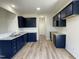 Modern kitchen with dark blue cabinets, stainless steel appliances, and granite countertops at 111 Bonsai Way, Four Oaks, NC 27524
