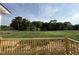 View of a grassy backyard and wooded area from the wooden deck, showcasing the property's outdoor space at 111 Coharie Dr, Lillington, NC 27546