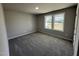 A cozy carpeted bedroom with two windows providing natural light and views of the surrounding landscape at 111 Coharie Dr, Lillington, NC 27546