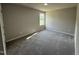 Carpeted bedroom with a large window offering natural light and a view of the outdoors at 111 Coharie Dr, Lillington, NC 27546