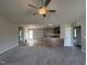 Open-concept living room flowing into the kitchen, with hardwood floors and a ceiling fan at 111 Coharie Dr, Lillington, NC 27546