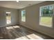 Bright living room featuring wood-look floors, white walls, and natural light from windows and patio door at 111 Mahogany Way, Four Oaks, NC 27524