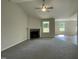 Bright living room with a corner fireplace, a ceiling fan, and views of the front yard at 111 Mahogany Way, Four Oaks, NC 27524