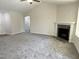 Large living room features a fireplace, neutral carpet, ceiling fan, and vaulted ceiling at 111 Mahogany Way, Four Oaks, NC 27524