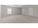 Neutral bedroom featuring plush carpet, ample natural light, and two entry doors at 1112 Monterey Bay Dr, Wake Forest, NC 27587