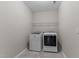Well-lit laundry room with washer and dryer and ample shelving for storage at 1112 Monterey Bay Dr, Wake Forest, NC 27587