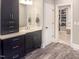 Bathroom featuring a double sink vanity with black cabinets, quartz countertops, and a view to the walk-in closet at 1218 Rogers Farm Rd, Wake Forest, NC 27587