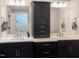 Bathroom showcasing double sink vanity with black cabinets and modern lighting and a door to the tub and shower area at 1218 Rogers Farm Rd, Wake Forest, NC 27587