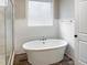Bathroom showcasing a freestanding white bathtub with modern fixtures, shiplap walls, and a window view at 1218 Rogers Farm Rd, Wake Forest, NC 27587