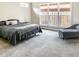 Spacious bedroom featuring large windows, neutral carpet, and a gray chaise lounge at 1218 Rogers Farm Rd, Wake Forest, NC 27587