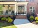 Inviting front porch with rocking chairs, hanging flower baskets, brick stairs, and double doors at 1218 Rogers Farm Rd, Wake Forest, NC 27587