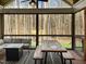 Relaxing screened porch featuring a dining table, cushioned seating, and a view of the forest at 1218 Rogers Farm Rd, Wake Forest, NC 27587