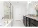 Modern bathroom featuring a soaking tub, frameless glass shower, and granite-topped double vanity at 1240 Gemfor St, Durham, NC 27703