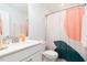 Well-lit bathroom featuring a modern vanity, toilet, and shower with a decorative curtain at 1240 Gemfor St, Durham, NC 27703