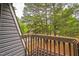 Balcony with wood railing offering tranquil views of the surrounding greenery and neighborhood at 127 Finley Forest Dr, Chapel Hill, NC 27517