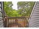 Balcony with wood railing providing a view of the neighborhood with lush green trees at 127 Finley Forest Dr, Chapel Hill, NC 27517