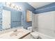 Bright bathroom with blue walls features a mosaic mirror, vanity, and tub with shower head at 127 Finley Forest Dr, Chapel Hill, NC 27517