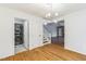 Open dining area with hardwood floors, modern light fixture, adjacent washer and dryer, and stairs at 127 Finley Forest Dr, Chapel Hill, NC 27517