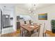 Dining space with open concept view of updated kitchen, hardwood floors, and modern light fixture at 127 Finley Forest Dr, Chapel Hill, NC 27517