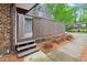 Cozy entrance with steps leading to a wooden patio, framed by lush landscaping and privacy fencing at 127 Finley Forest Dr, Chapel Hill, NC 27517