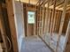 Unfinished bathroom featuring framed walls, plumbing, and a window, awaiting transformation into a modern retreat at 136 Tuskeegee Dr, Smithfield, NC 27577