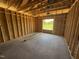Unfinished bedroom with wood framing, concrete floors, and a window for lots of light at 136 Tuskeegee Dr, Smithfield, NC 27577