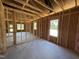 Framed bedroom with exposed studs and a window, ready for customization to create a personalized living space at 136 Tuskeegee Dr, Smithfield, NC 27577