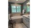 This bathroom boasts a soaking tub under a window with plantation shutters and a white vanity with double sinks at 137 Cofield Cir, Durham, NC 27707