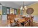 Well-lit dining room with hardwood floors, wainscoting, classic decor, and staircase view at 137 Cofield Cir, Durham, NC 27707