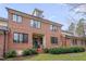 Back exterior brick home with lush landscaping, windows and a covered patio at 137 Cofield Cir, Durham, NC 27707