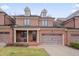 Charming brick townhouse featuring a two-car garage and welcoming front porch seating at 137 Cofield Cir, Durham, NC 27707
