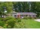 Quaint one-story home featuring brick accents, established shrubs, and a well-maintained lawn at 1405 Kenbrook Dr, Garner, NC 27529