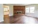 Warm living room featuring wood-look flooring, a brick fireplace, and abundant natural light at 1405 Kenbrook Dr, Garner, NC 27529