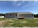 Backyard featuring a gray single story home with a small back porch and light colored roof at 152 Tulipfield Way, Benson, NC 27504