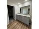 Bathroom featuring double vanity with gray cabinets, granite countertop, and a large mirror at 152 Tulipfield Way, Benson, NC 27504